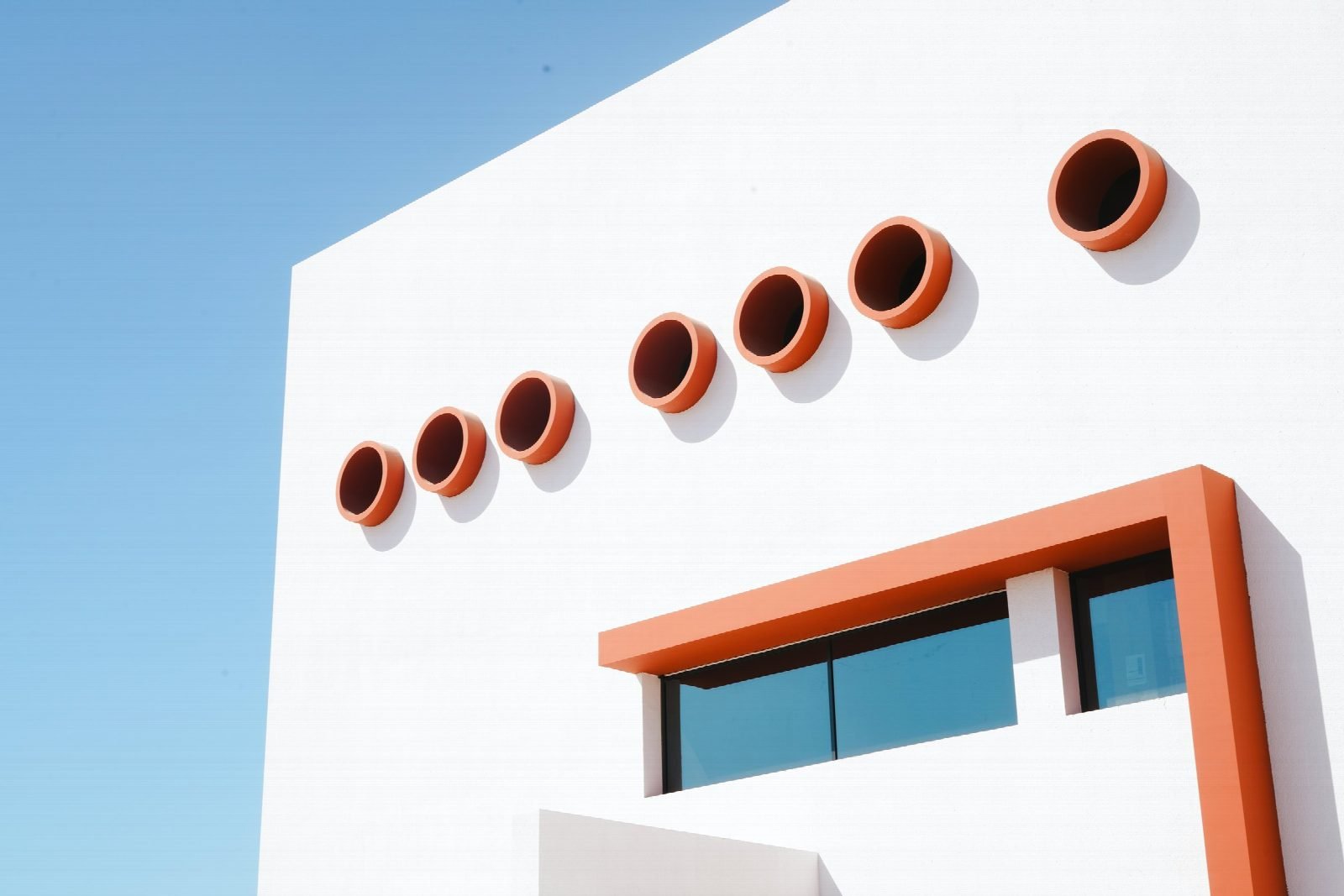 Round openings and shading frame on the façade.
