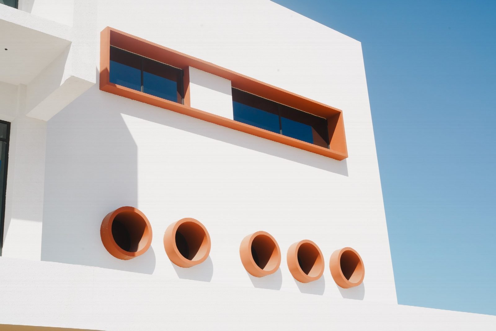 Façade detail with the orange window frames.